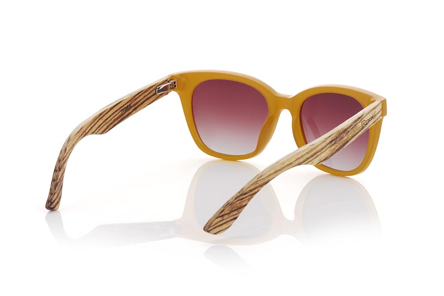 Wood eyewear of Walnut NORA. NORA sunglasses combine a frame in an attractive satin orange tone with walnut wood temples to offer a fresh and natural design. This model with its rounded shapes and ideal size has a slight retro touch and is perfect for women, although it can also look good on daring men. Gradient brown or gray-toned lenses add an elegant touch to these wooden sunglasses. Enjoy a unique style and the protection you need anywhere with the NORA sunglasses from Root. Front Measurement: 143x50mm Caliber: 49 for Wholesale & Retail | Root Sunglasses® 
